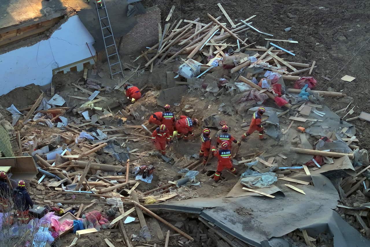 An aerial view of rescue workers working among debris.