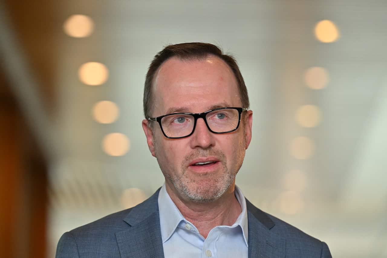 A man in a grey suit and glasses 