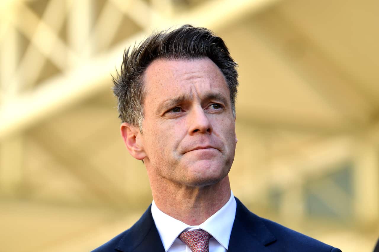 A man in awhite shirt blue suit and pink tie