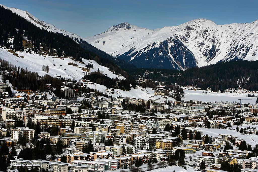 Aerial view of a snow-covered covered town, with mountains in the distance