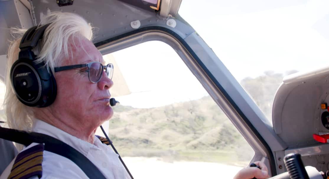 an older man flying a plane