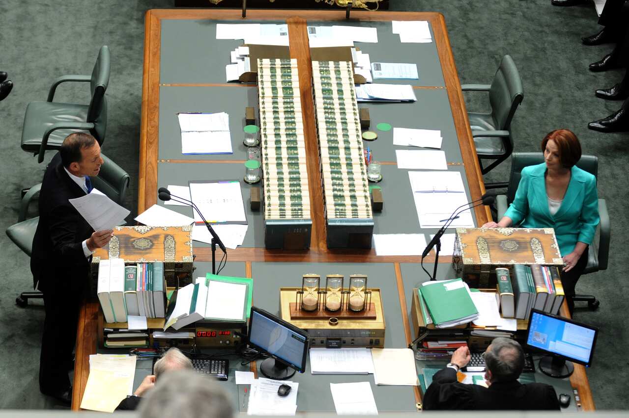Then Opposition leader Tony Abbott standing and talking in parliament across the table from a seated Julia Gillard.