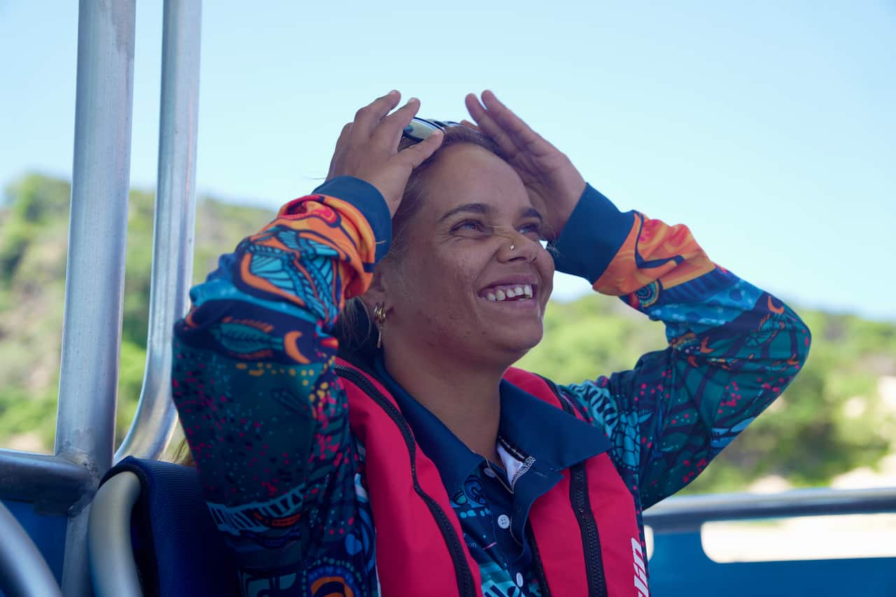 Woman wearing red life jacket on boat smiling
