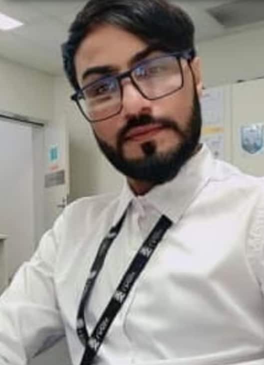 A screenshot showing a portrait image of a man with dark hair in a white shirt.
