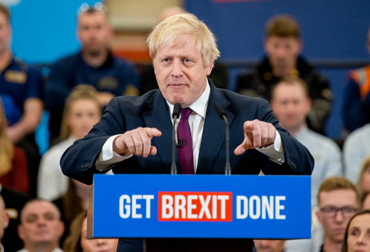A man pointing while standing at a podium.