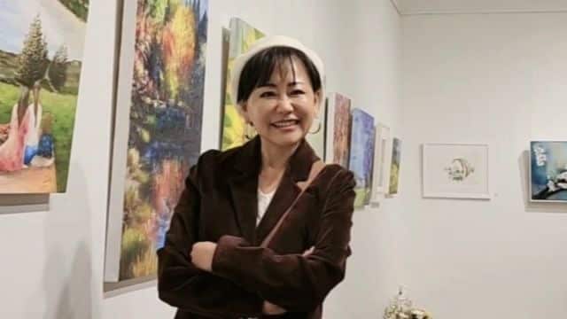 A woman smiles with her arms crossed. 