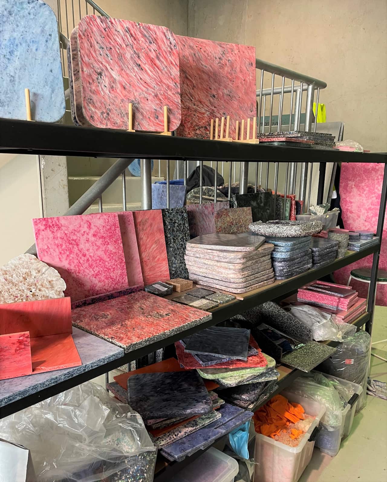 Colourful cutting boards and other items on shelves in a warehouse.