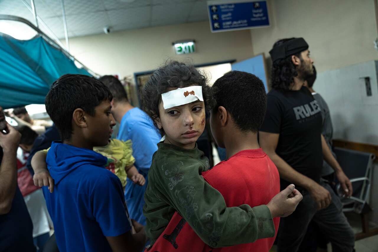 An injured young boy is carried into a hectic hospital in Gaza.