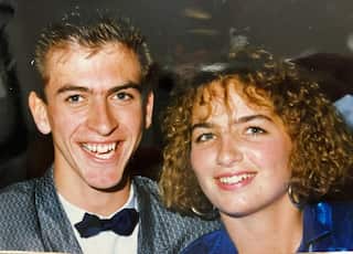 a closeup of a young man and woman couple. The man is wearing a bow tie and the woman has a shoulder length perm