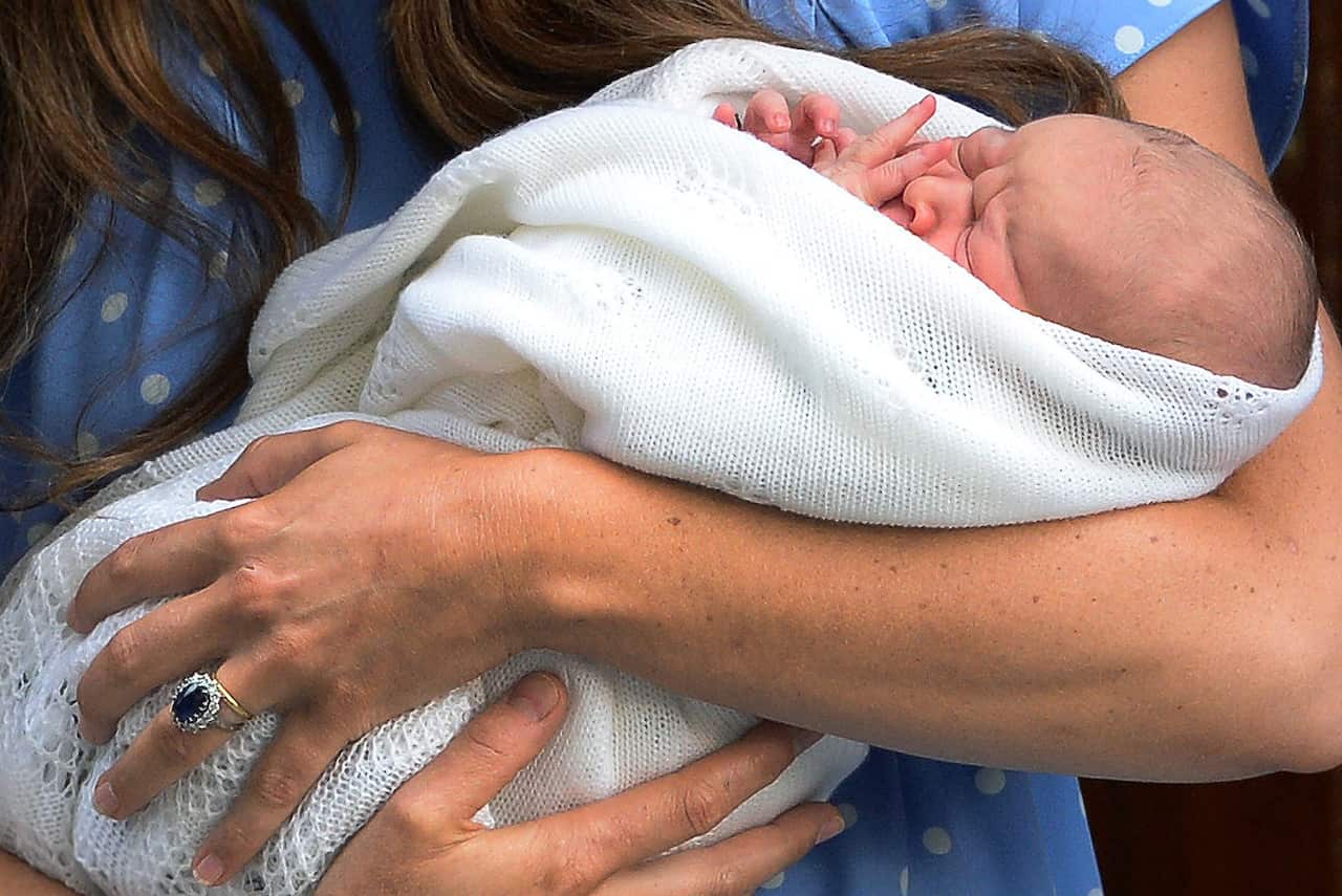 A close up image of newborn Prince George being held by his mother, the Duchess of Cambridge