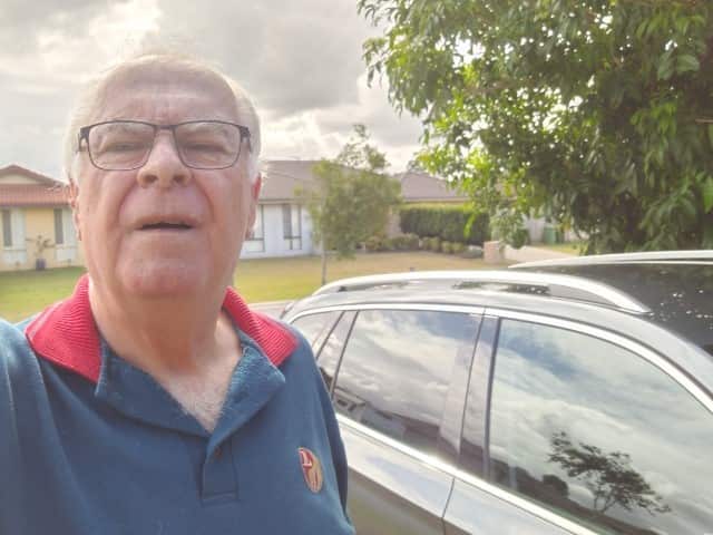 Driver Les Johnson standing next to his car