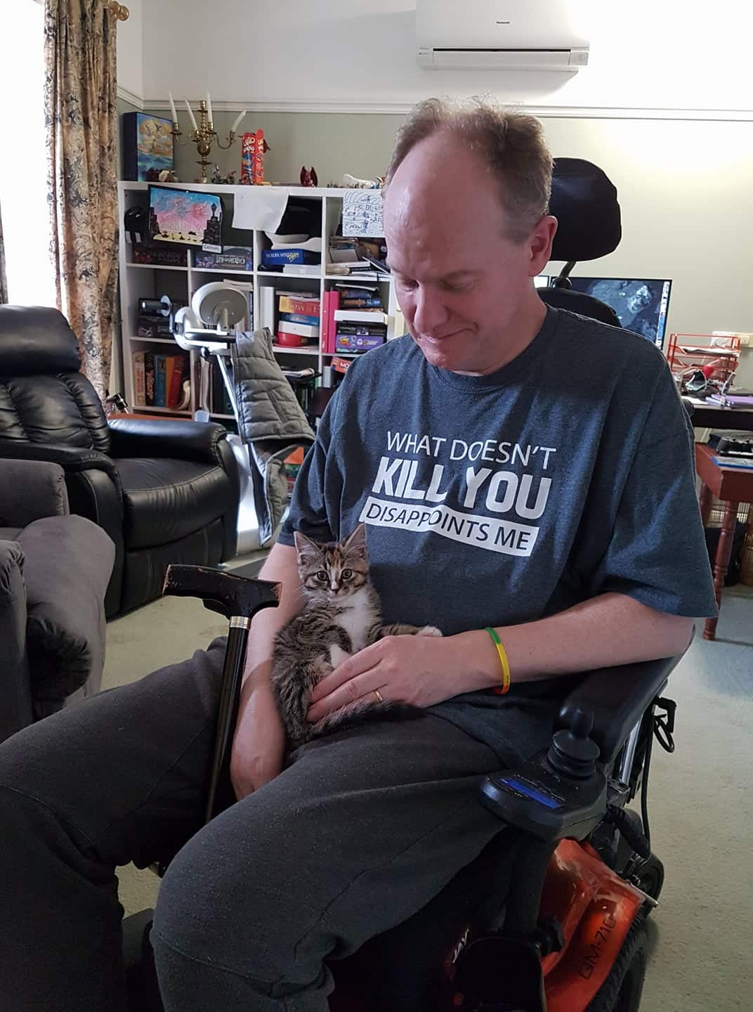 Colette's husband with a kitten on his lap. 