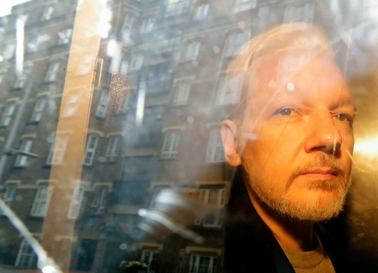 Julian Assange seen through a car window in 2019.