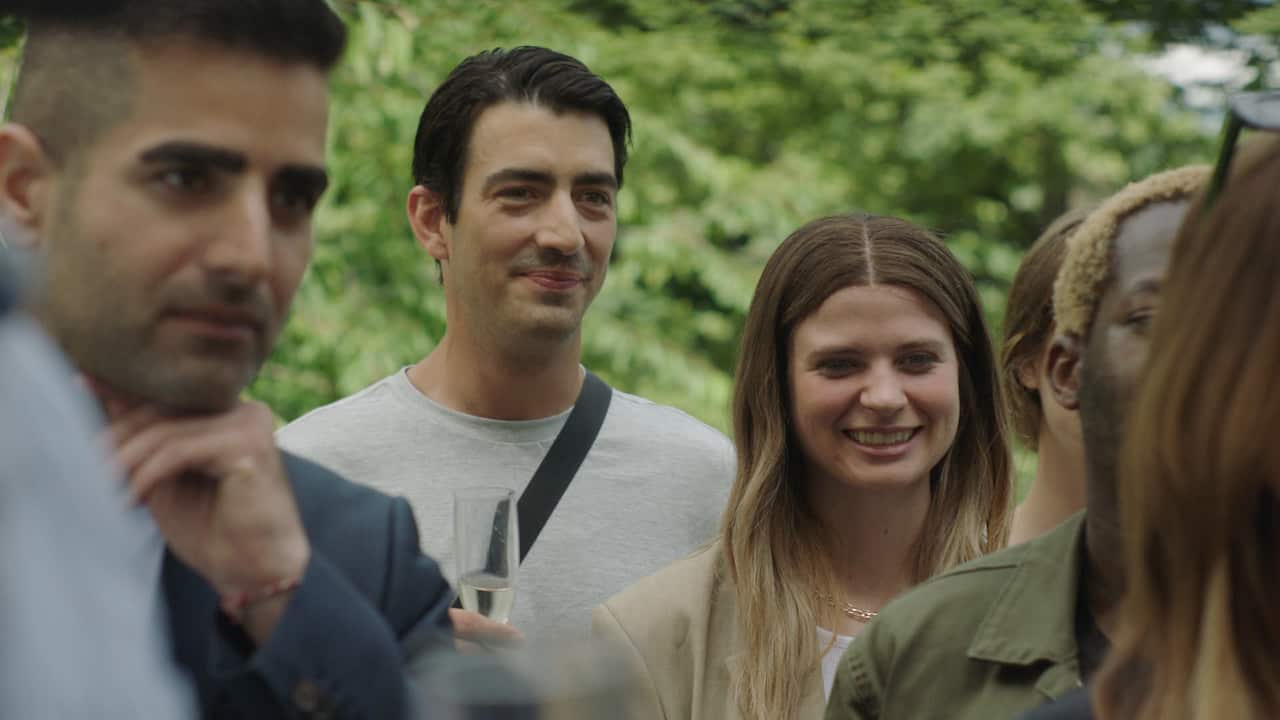 A group of young people, focused on a man and woman, stand smiling.png