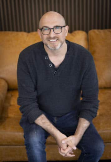 a man sitting down wearing a blue shirt