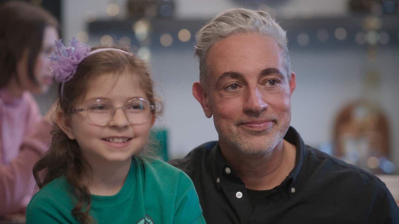 A man and his daughter are next to each other smiling