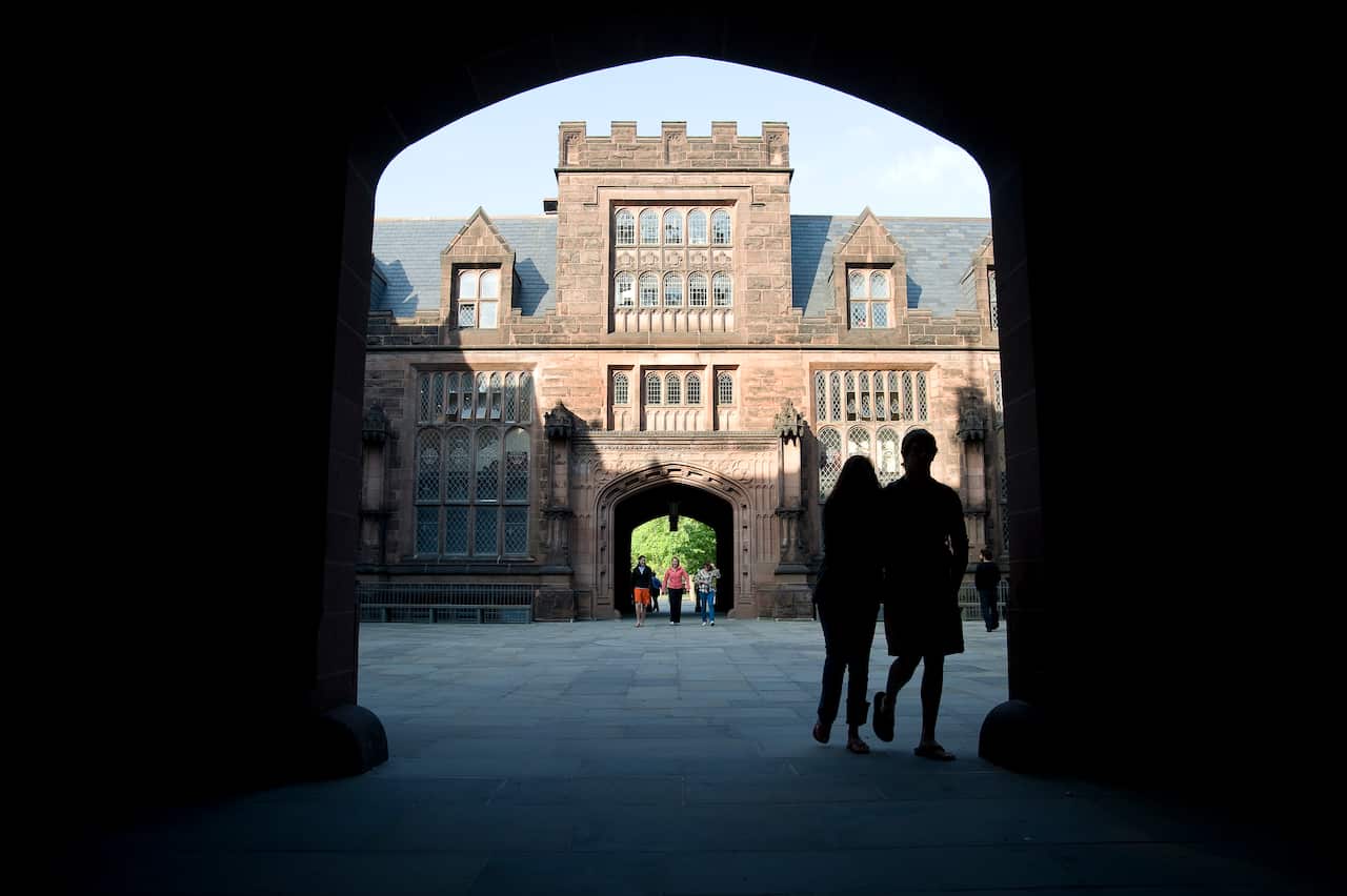 Two figures in shadow walking through an archway 