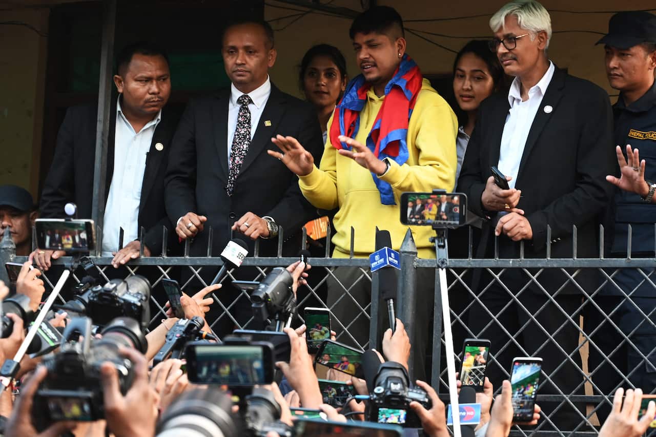 Sandeep Lamichhane (C) gestures to the crowd gathered outside Patan High Court at Lalitpur district in Kathmandu on 15 May 2024, after his acquittal by the court in a rape case.