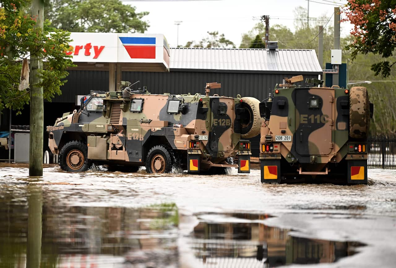 Army vehicles are seen driving through floodwater.