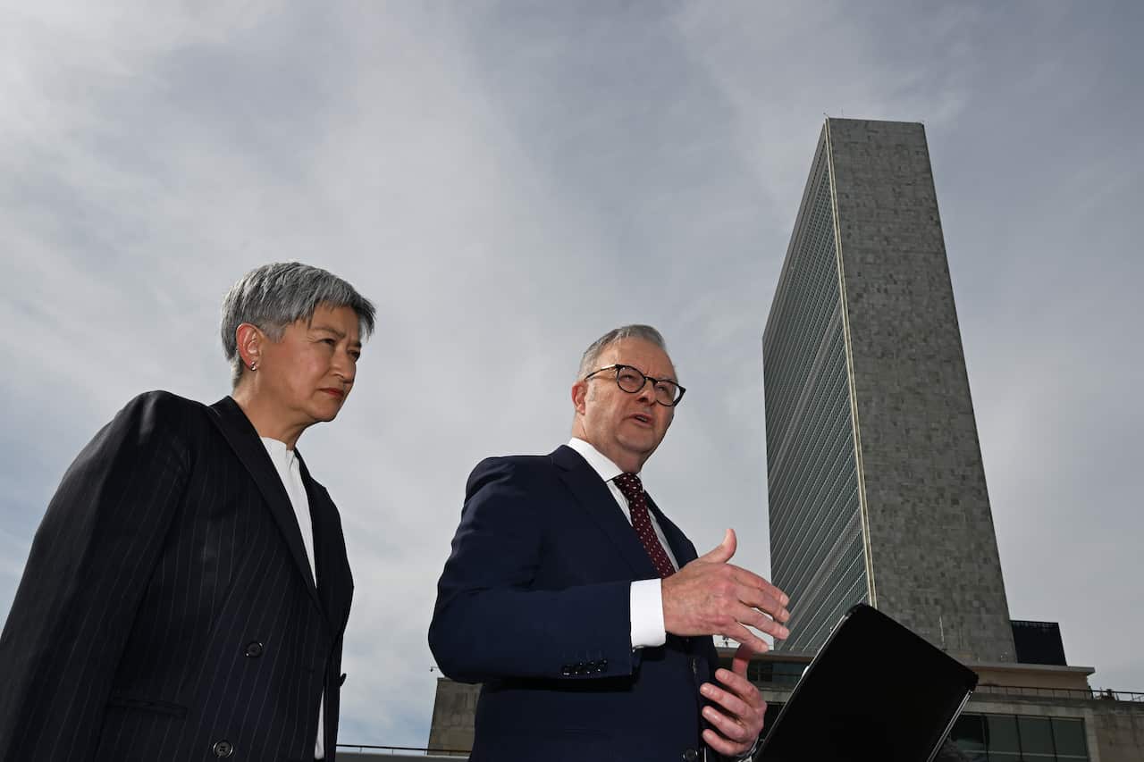 A man and a woman in a suit underneath a building