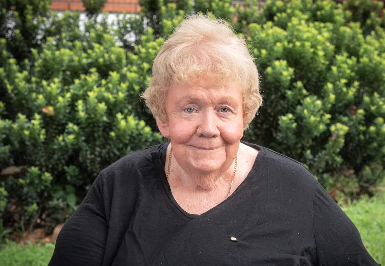 A woman wearing a black top and sitting in a garden