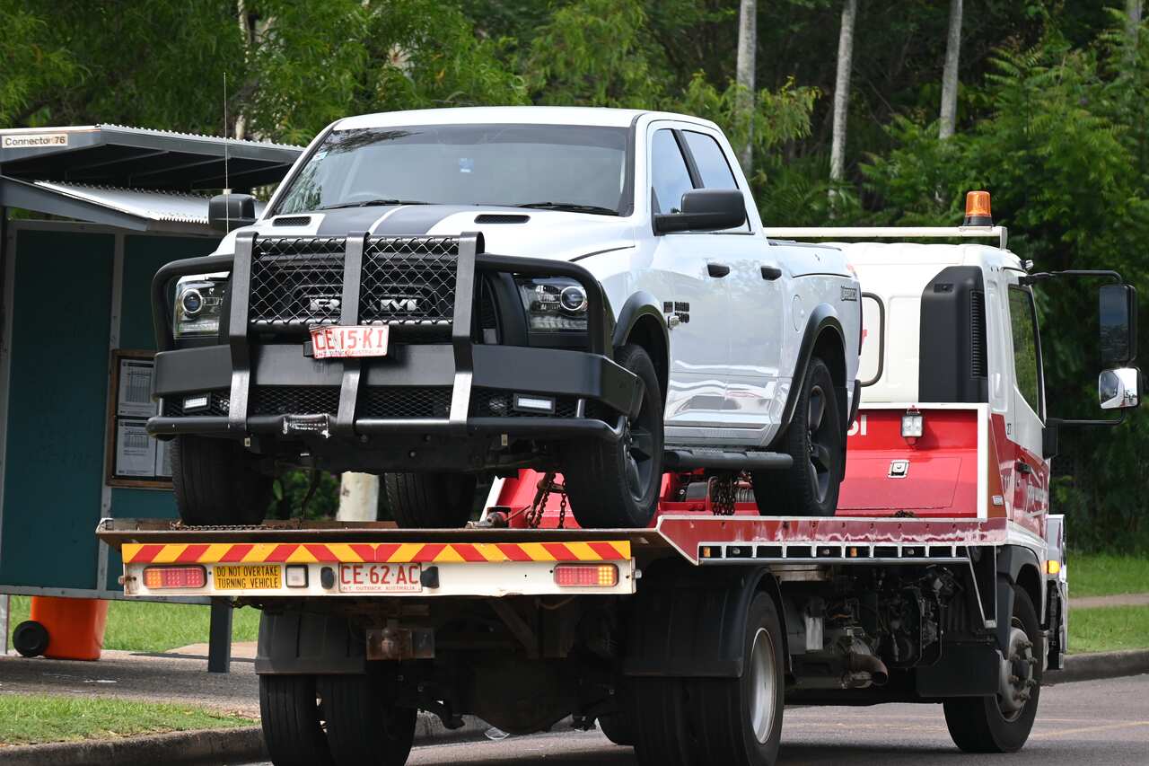 A white Ram 1500 four-wheel-drive ute on the back of a truck. The large bull bar has been dented and blood can be seen across the damaged number plate.