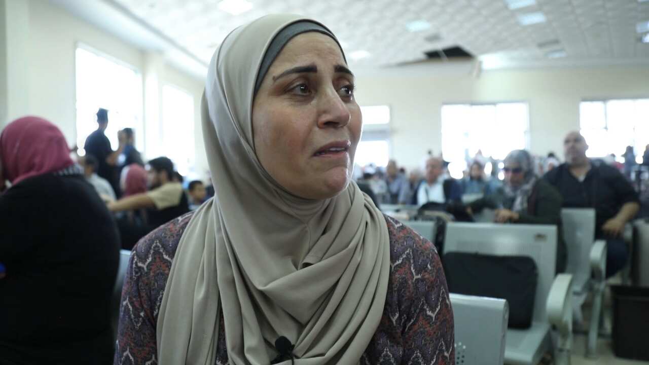 A woman wearing a hijab speaking while seated.