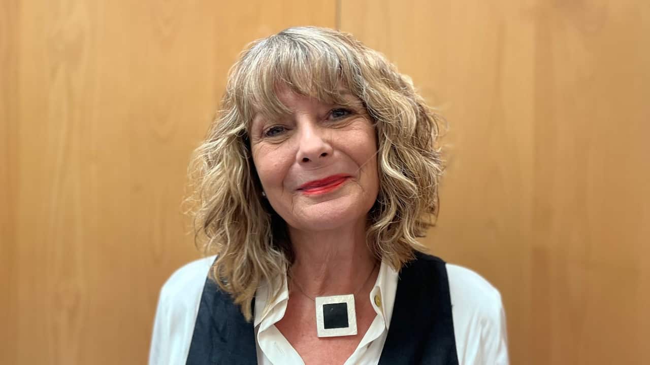 a close up of middle aged blonde woman wearing red lipstick