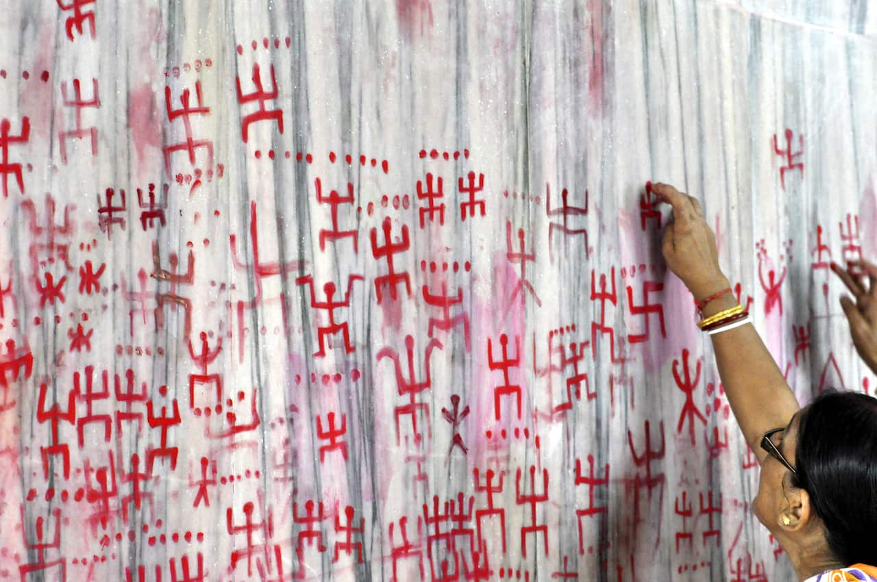 Indian women seen drawing the holy sign of Swastika during