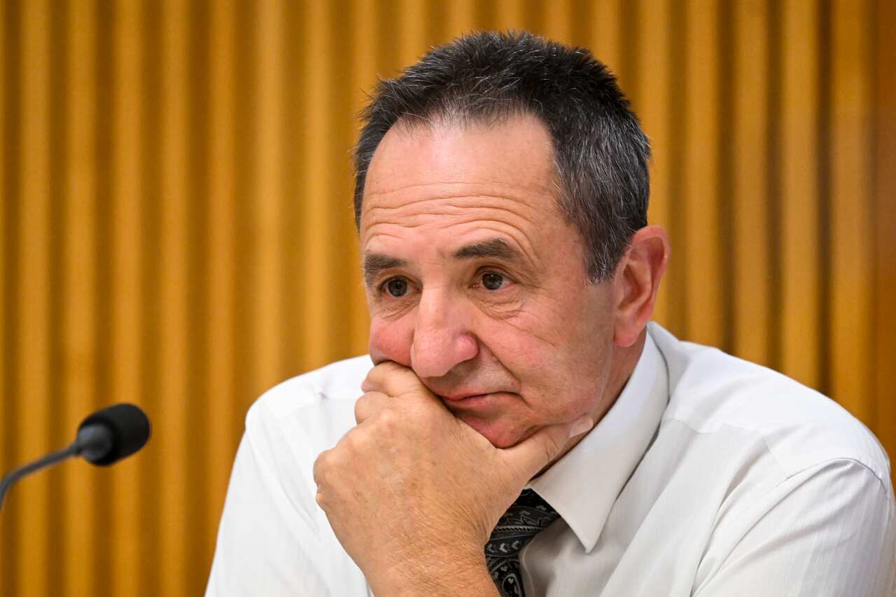 A man rests his chin in the palm of his hand