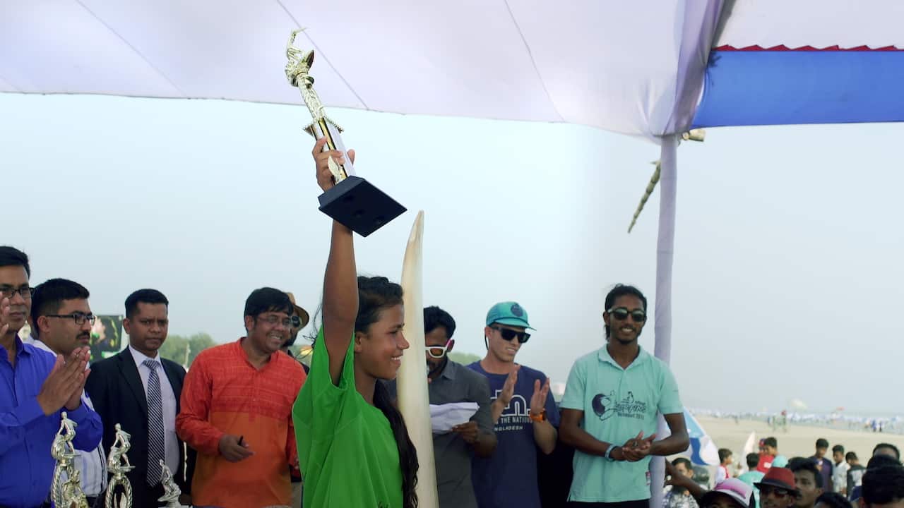 A girl holding a trophy.