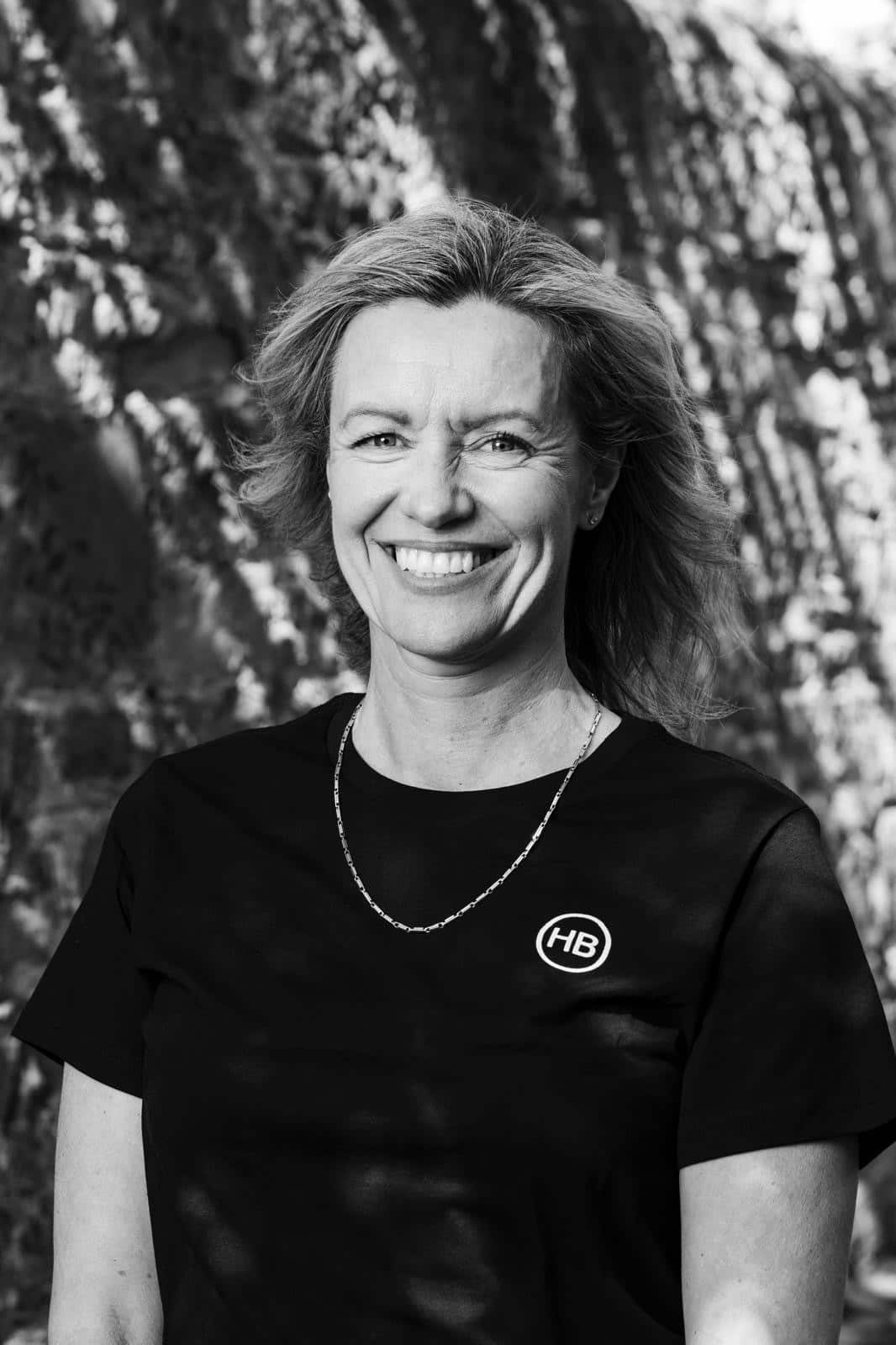 Black and picture of a smiling woman wearing a t-shirt.