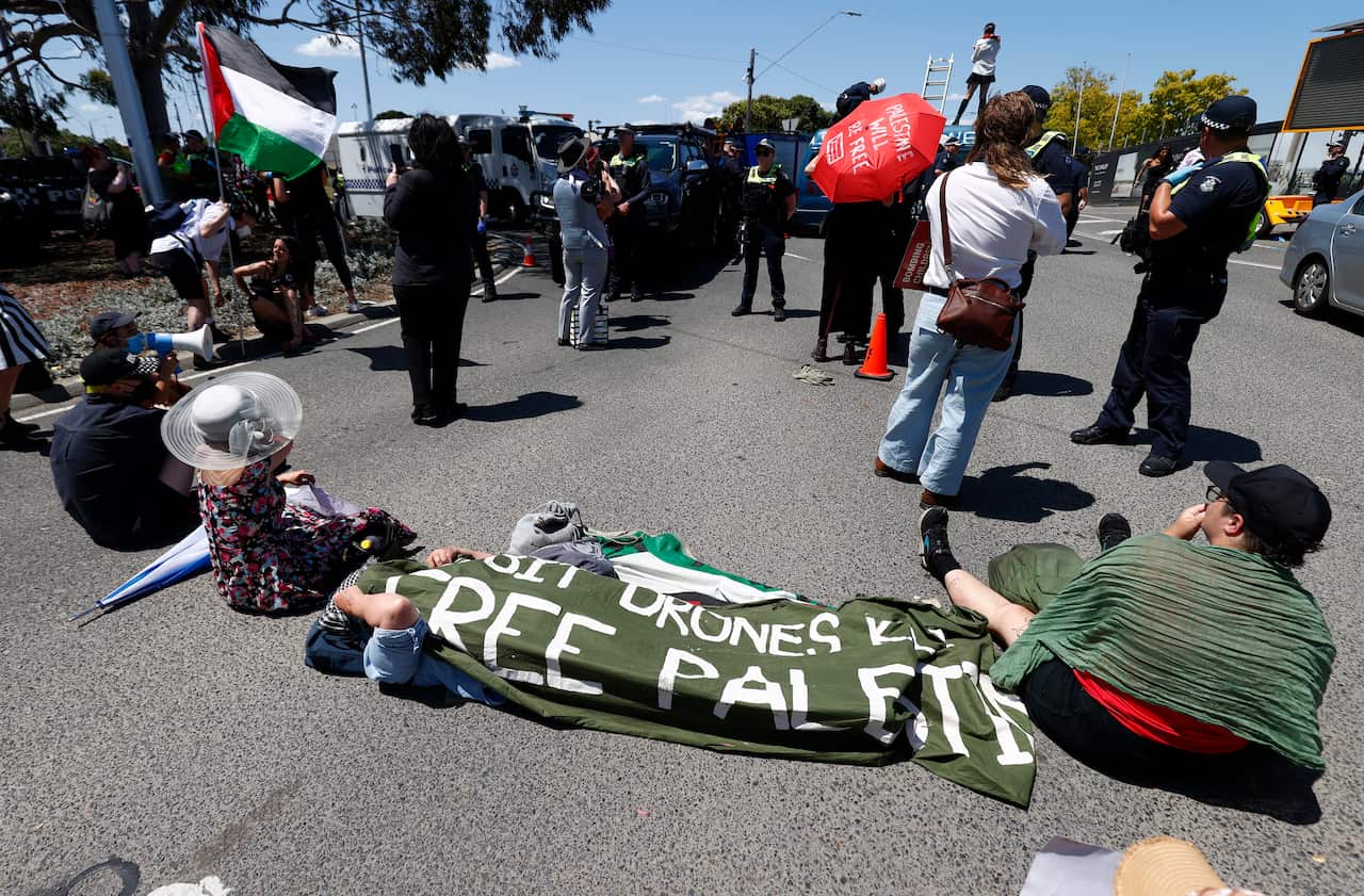 People sitting on the ground with pro-Palestinian banners