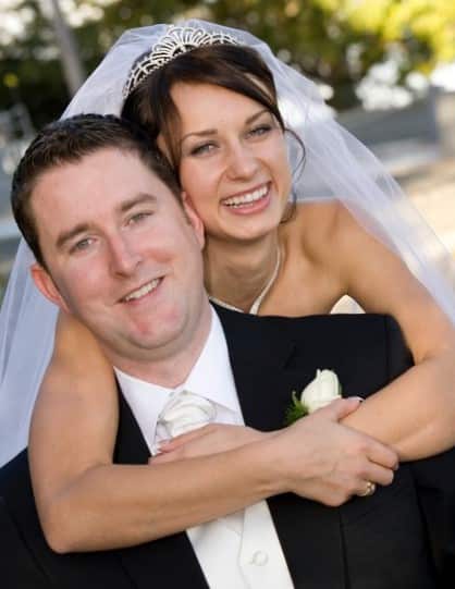 A man in a suit and tie and a woman in a bridal dress and veil