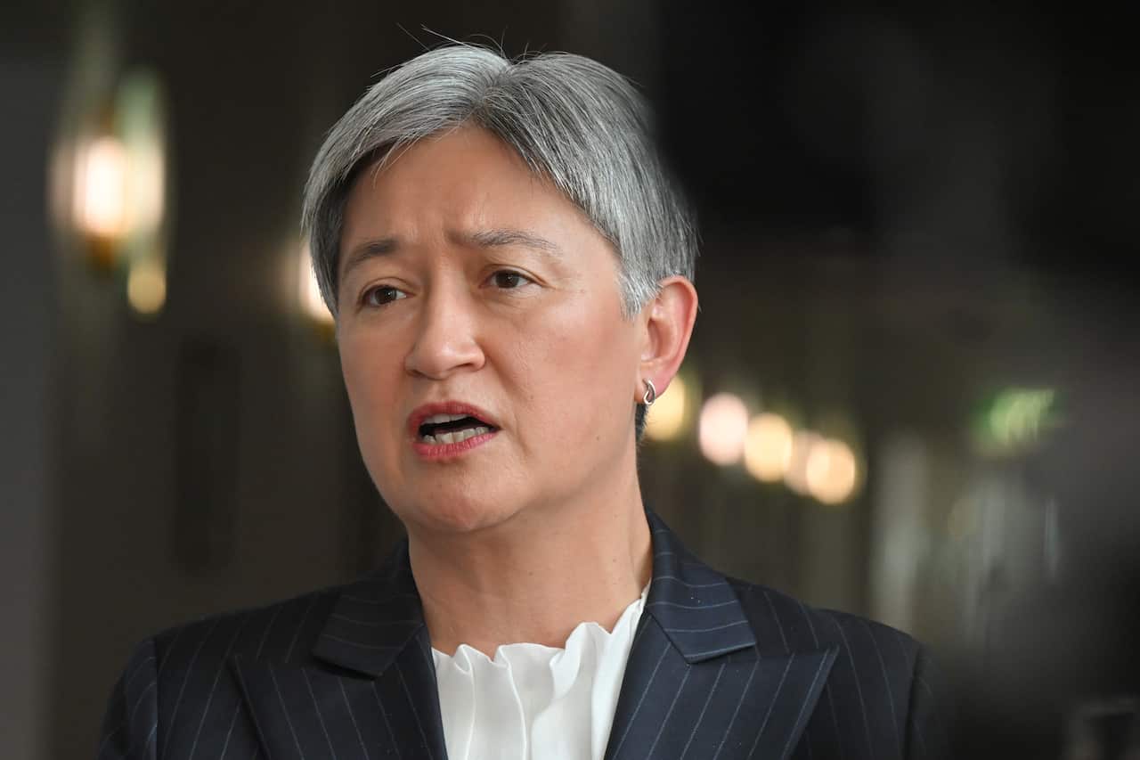 A woman with cropped silver hair in a black blazer is speaking.