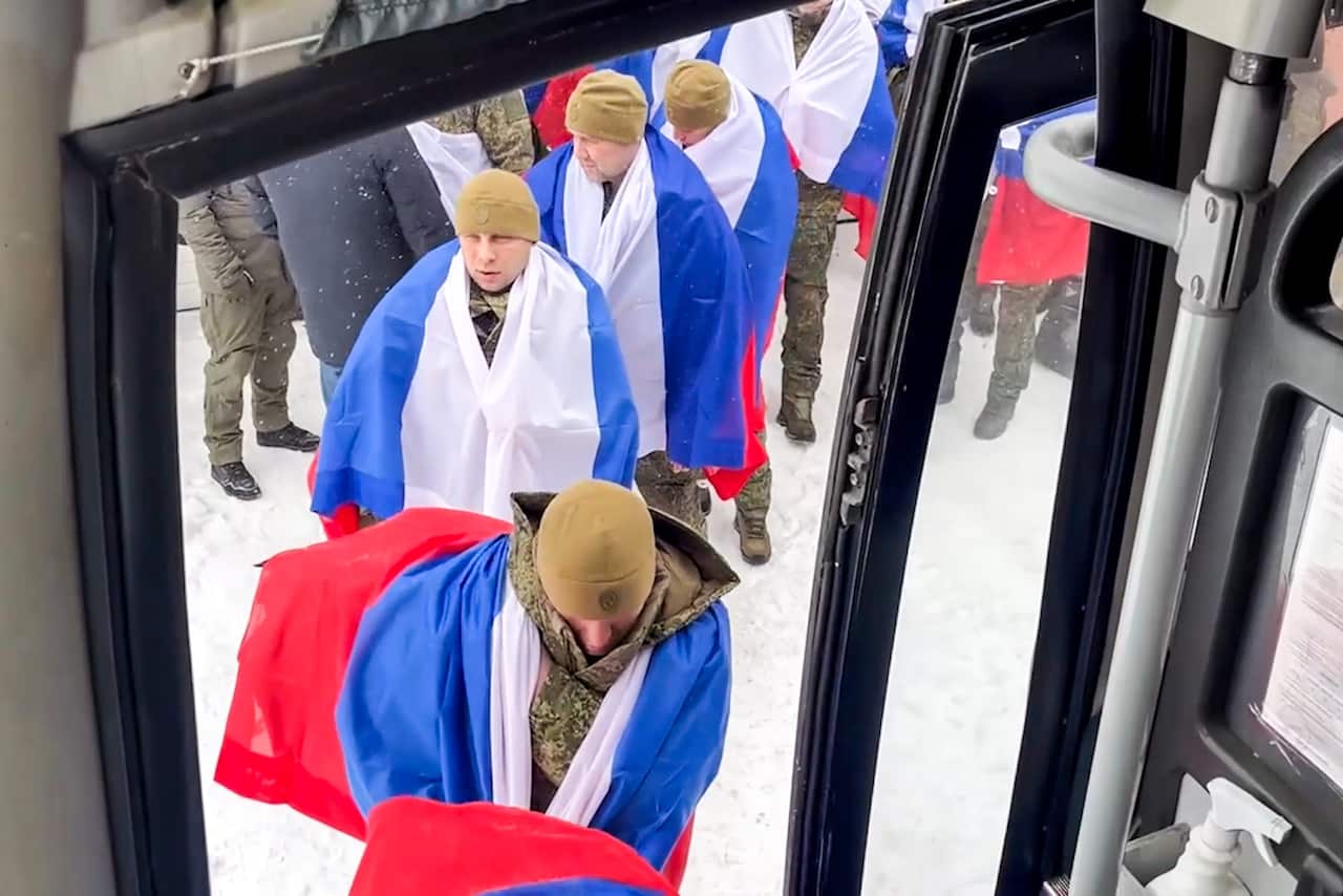 Russian servicemen released from Ukrainian captivity, board a bus. 