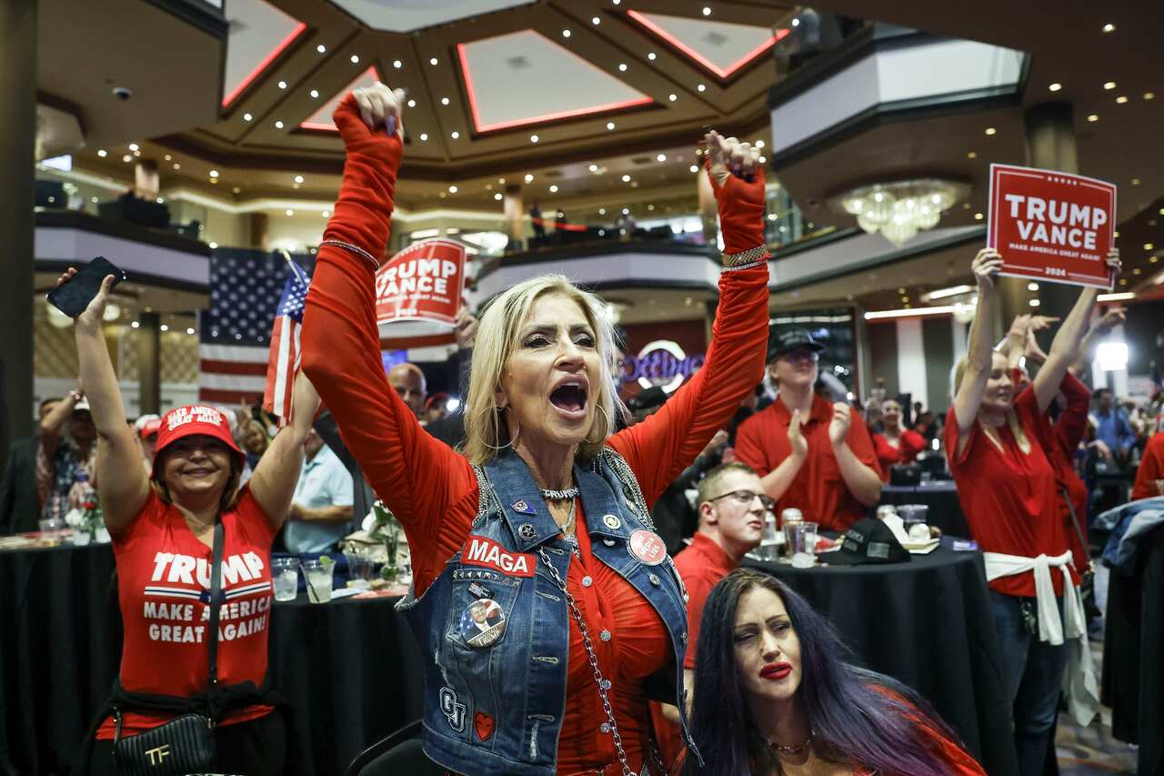 A group of people wearing red shirts. Some have their arms in the air