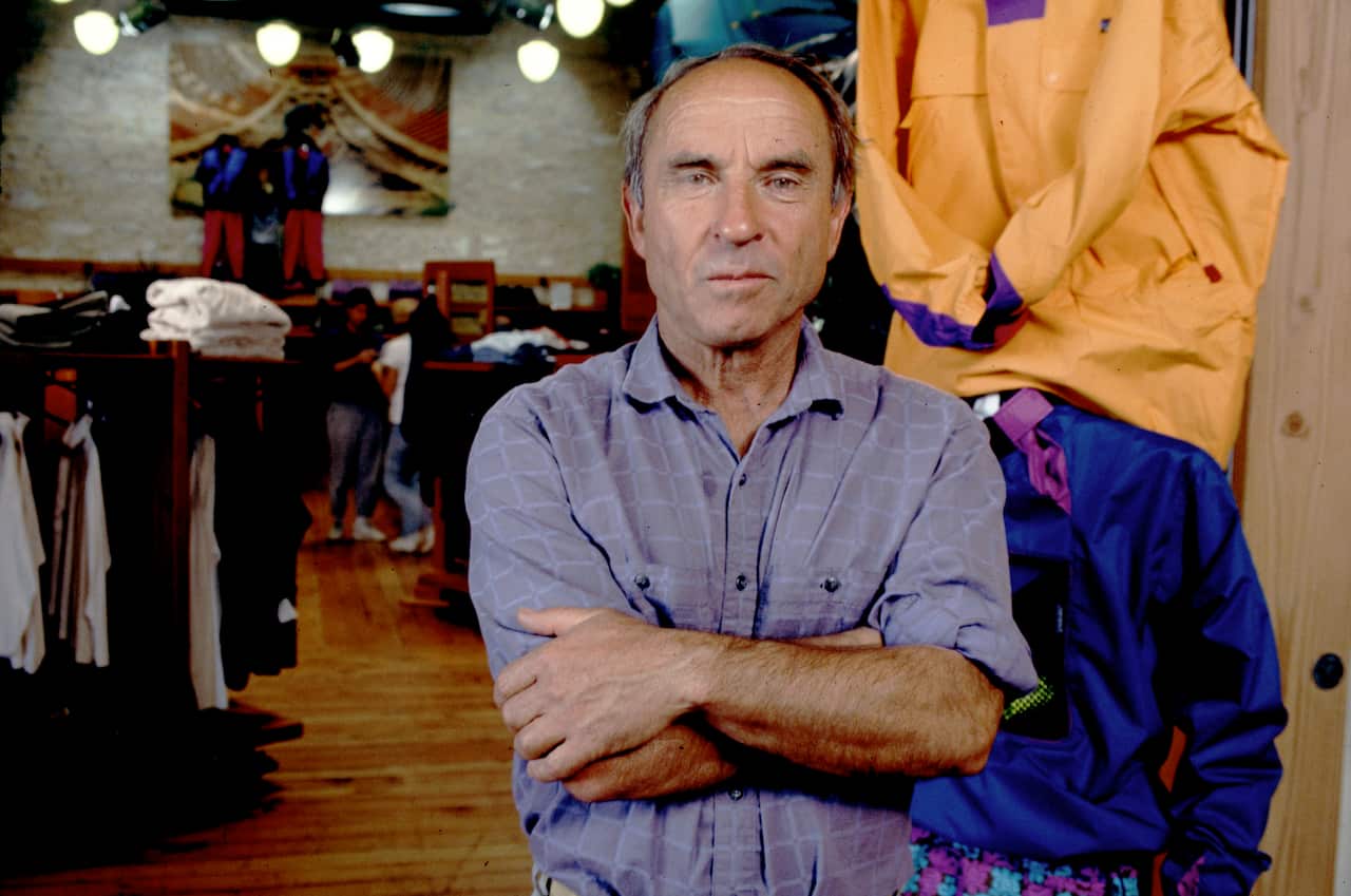 A man in a button-up stands in a store. 