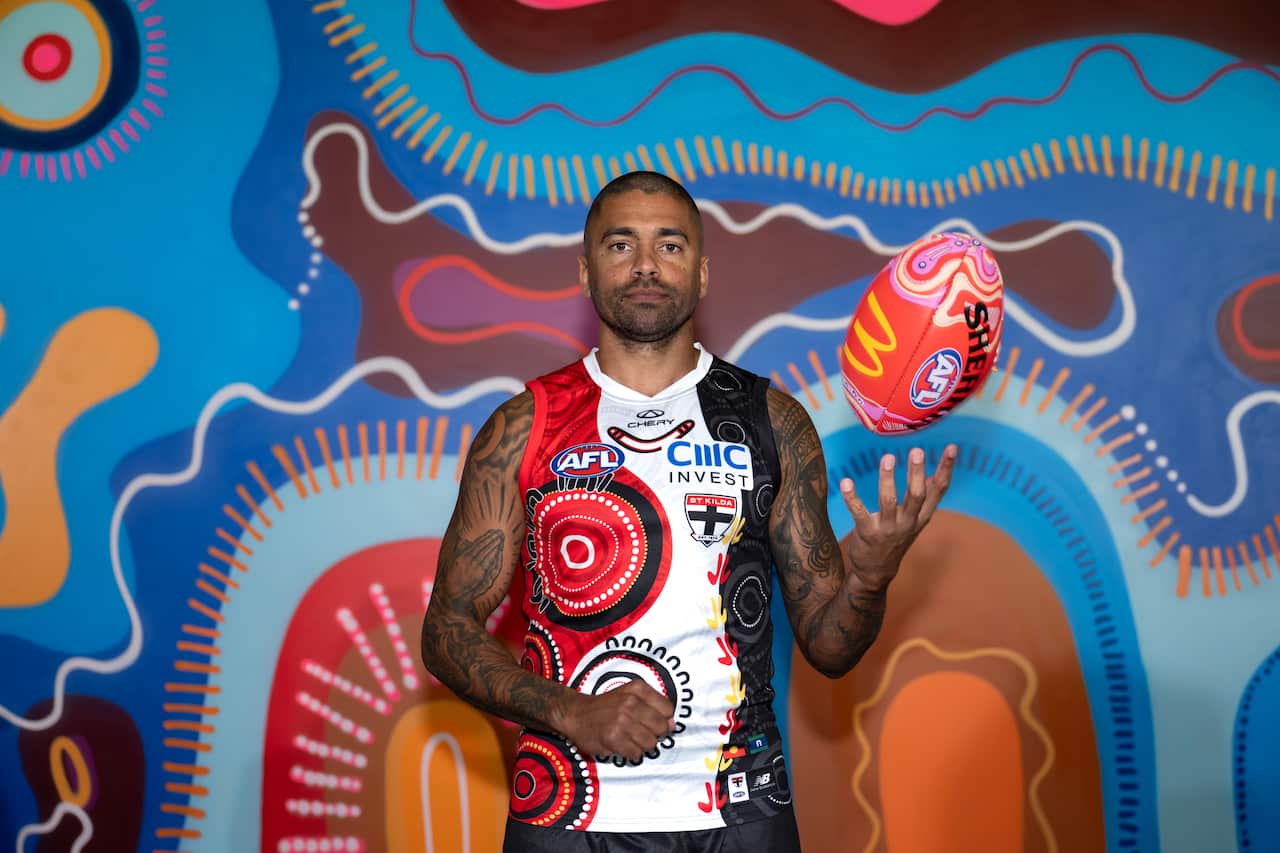 AFL player Bradley Hill hand-balling a Australian Rules Football to himself.