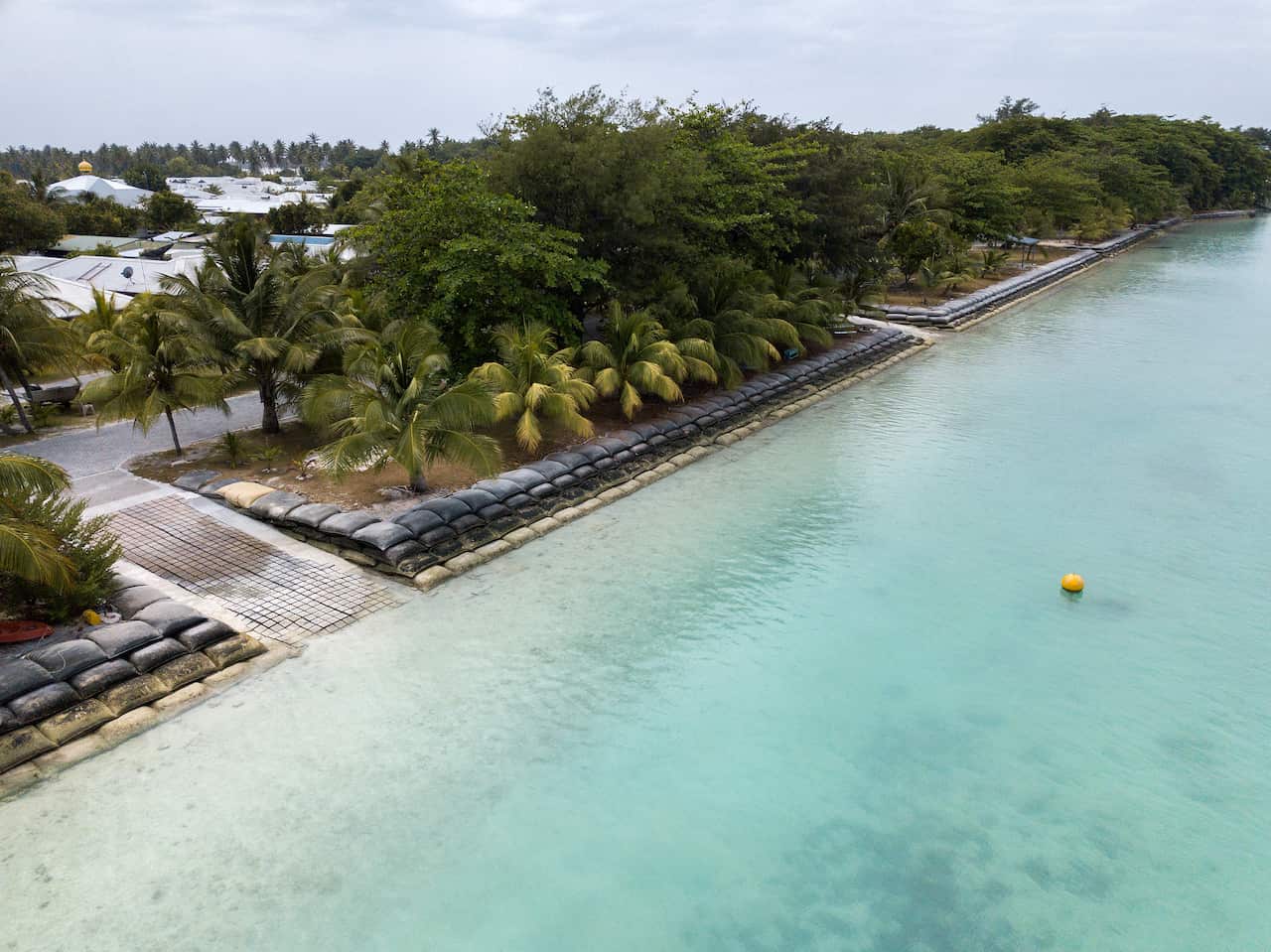 An overhead view of a shoreline with water meeting it.