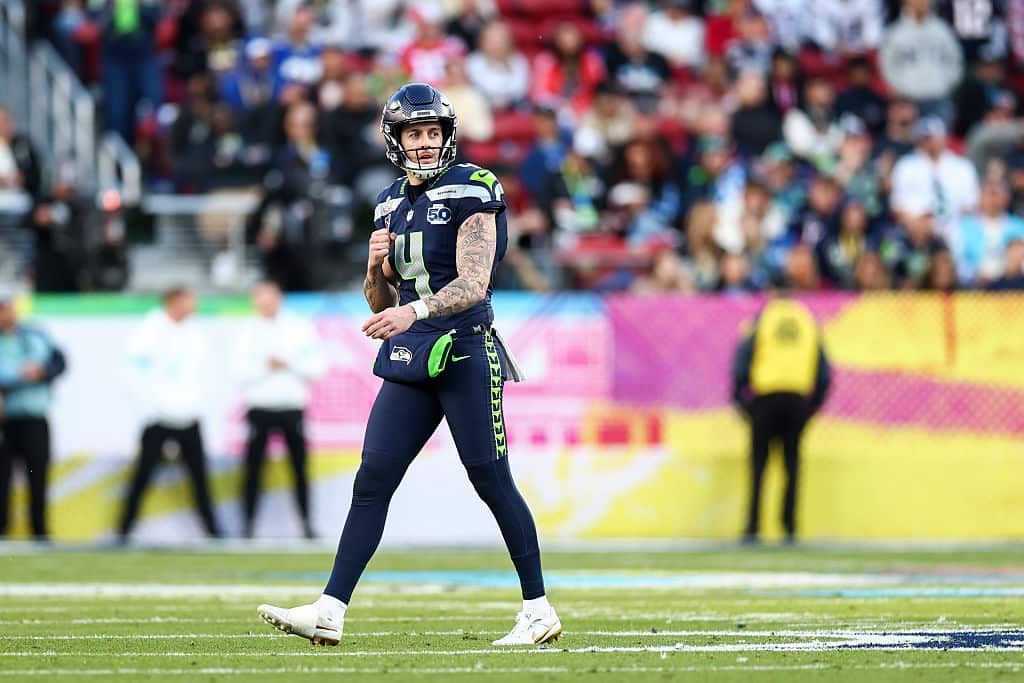 A man in a dark American Football uniform on the field