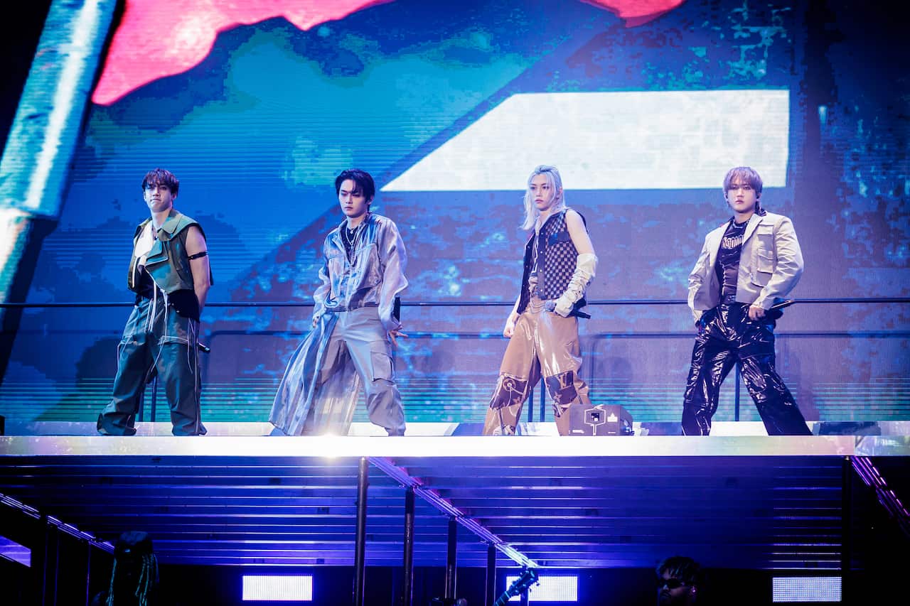 Four male singers performing on a stage.