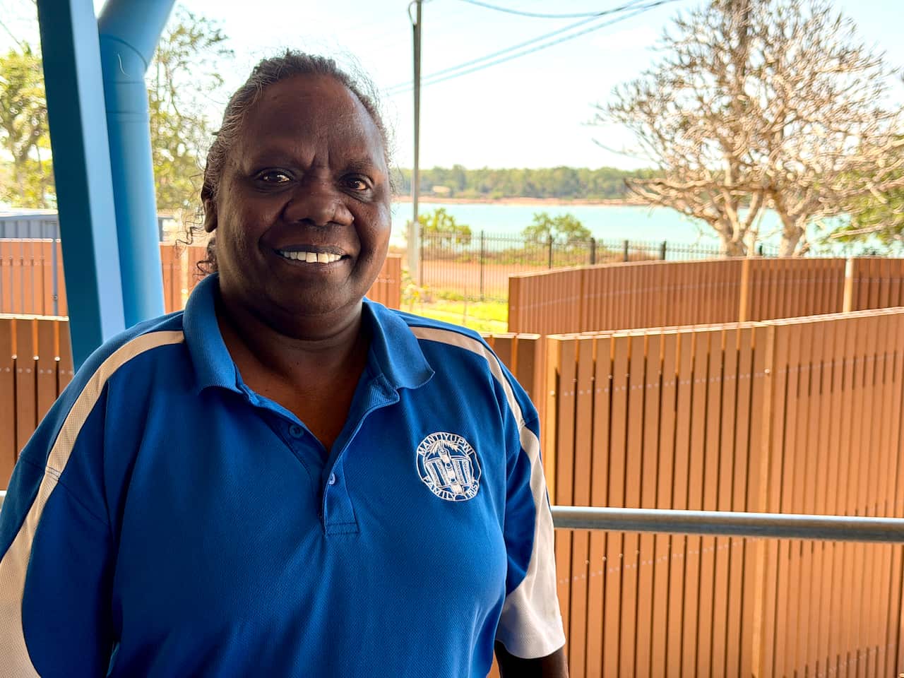 A wearing a blue shirt and smiling