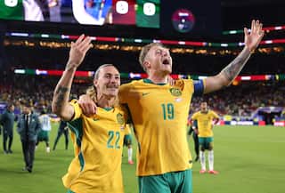 Harry Souttar and Jackson Irvine wearing green and gold colours