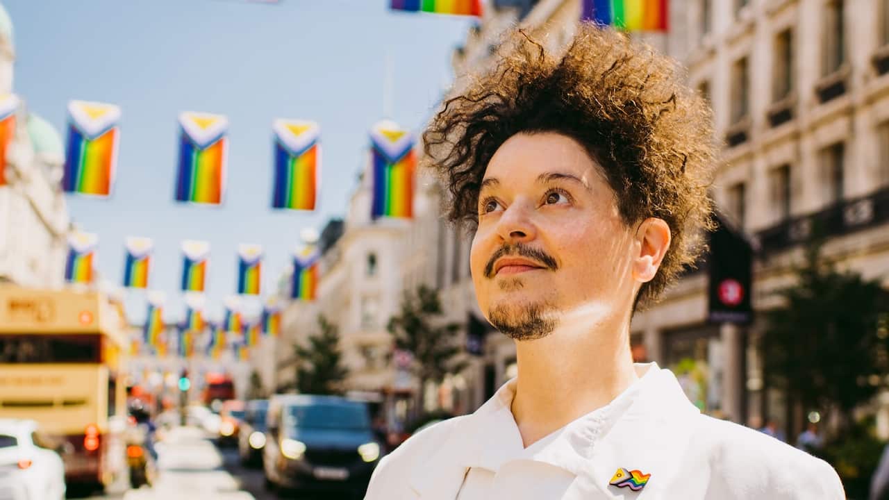 Valentino Vecchietti standing in street with pride flags in background