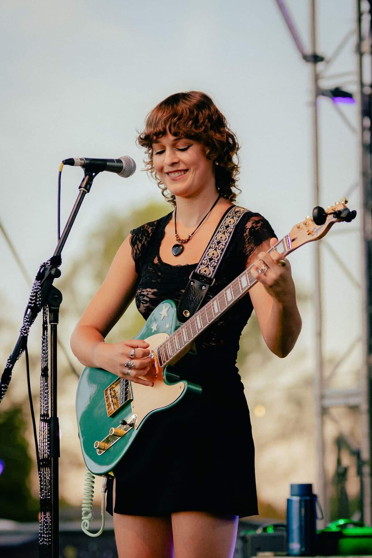 A woman playing the guitar on a stage.