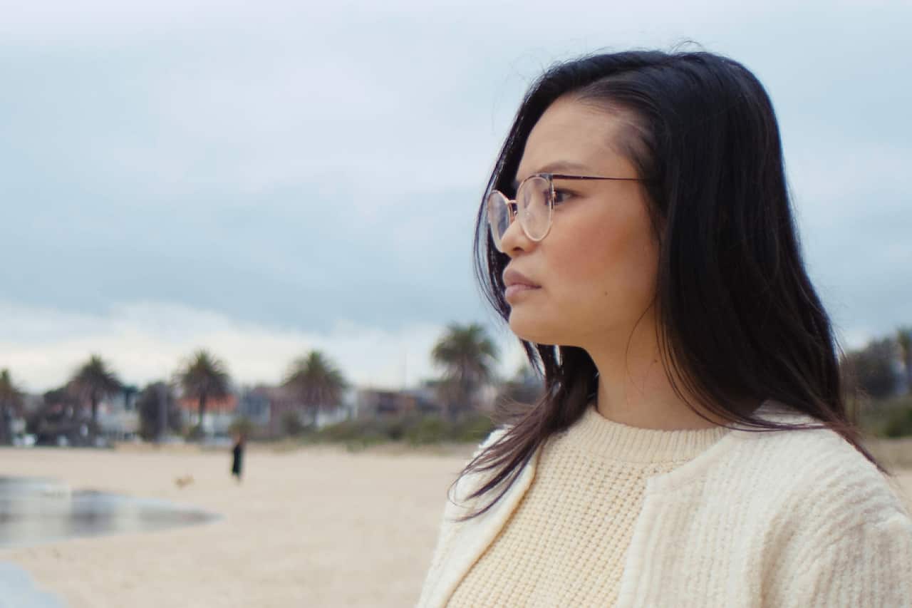 Thu Fampidi is seen from the side profile as she looks into the distance at the beach. 