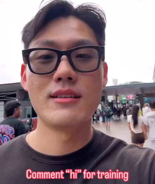  A man wearing black wayfarer glasses walks through a crowded street. The text on screen reads: Comment "hi" for training