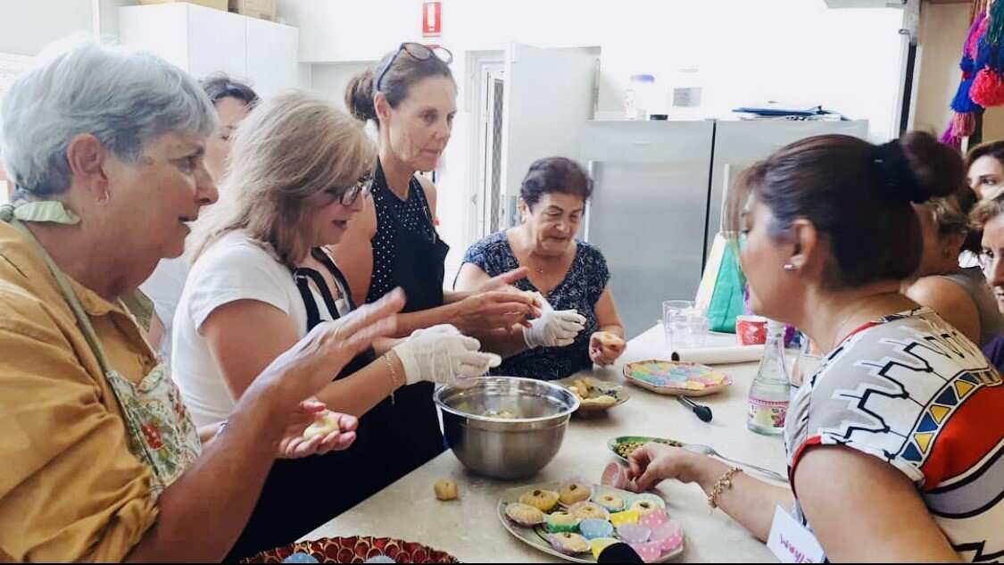 Group photo of women cooking at the welcome centre