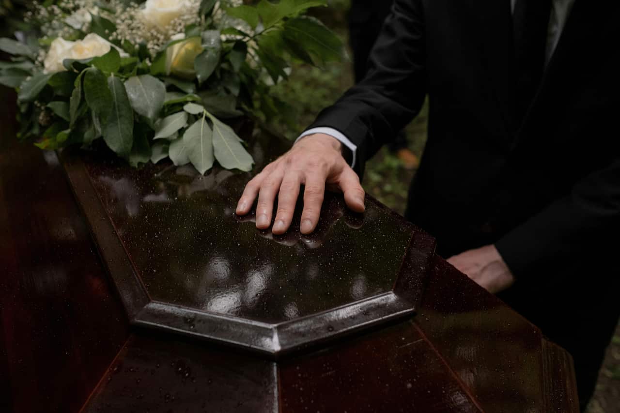 Photo-A hand on a coffin-pexels-cottonbro studio.jpg